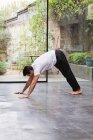 Homme pratiquant la pose de yoga de chien vers le bas — Photo de stock
