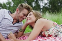 Paar legt sich auf Picknickdecke — Stockfoto
