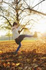 Ragazza sorridente che gioca in foglie di autunno — Foto stock