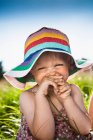Toddler girl wearing sunhat in grass — Stock Photo