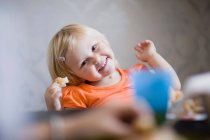 Menina da criança sorrindo à mesa de jantar — Fotografia de Stock