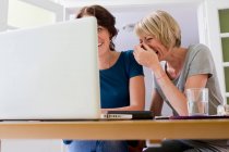 Women using laptop together — Stock Photo