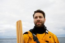 Портрет каякера, стоящего против моря — стоковое фото