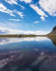 Nuvole e montagne riflesse nel lago — Foto stock