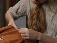Nahaufnahme junger Designerinnen beim Nähen orangefarbener Stoffe — Stockfoto
