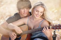 Paar spielt gemeinsam Gitarre — Stockfoto
