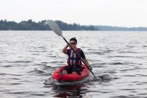 Donna kayak sul lago ancora — Foto stock