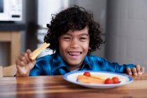 Retrato de sorrindo menino comer lanches — Fotografia de Stock