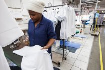 Arbeiter bügelt Hemd in Bekleidungsfabrik — Stockfoto