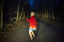Donna che corre nella paura nei boschi di notte — Foto stock