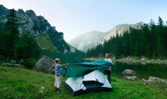 Vater und Sohn schlagen gemeinsam Zelt auf — Stockfoto