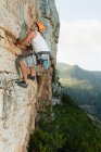 Climber scaling steep rock face — Stock Photo