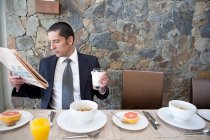 Businessman eating breakfast at home — Stock Photo