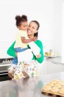 Madre e hija riendo en la cocina - foto de stock