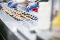 Cropped image of multicultural Factory workers on tofu sausages production line — Stock Photo