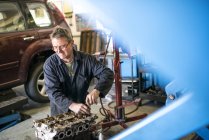 Mechanic working on car parts in garage — Stock Photo