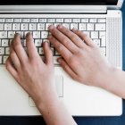 Vista superior de las manos en el teclado portátil - foto de stock