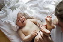 Pai brincando com bebê filha na cama — Fotografia de Stock