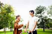 Улыбающаяся пара разговаривает в парке, избирательный фокус — стоковое фото