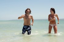 Couple playing in water at beach — Stock Photo