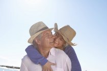 Пара носить солом'яні капелюхи на пляжі — стокове фото
