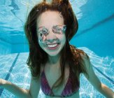 Улыбающаяся девушка под водой в бассейне — стоковое фото