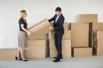 Бизнесмен и женщина поднимают картонную коробку — стоковое фото