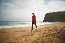 Жінка біжить на пляжі — стокове фото