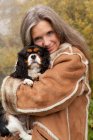 Літня жінка обіймає собаку на відкритому повітрі — стокове фото