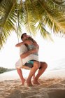 Пара обнимающихся на качелях на пляже — стоковое фото
