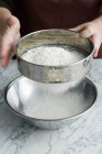 Immagine ritagliata di Chef setacciando farina in ciotola — Foto stock
