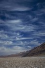 Скалистая сельская дорога под облачным небом — стоковое фото