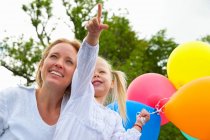 Mother and daughter holding balloons — Stock Photo