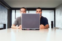 Businessmen using laptop together — Stock Photo