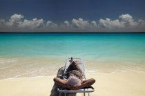 Donna anziana che si rilassa sulla spiaggia — Foto stock