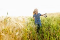 Девочка бежит по пшеничному полю — стоковое фото