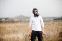 Хлопчик у газовій масці на пшеничному полі — стокове фото