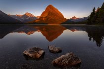 Vista de tres rocas contra el lago y las montañas - foto de stock