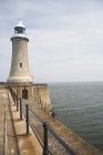 Lighthouse and harbor wall — Stock Photo