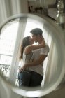 Couple kissing in mirror — Stock Photo
