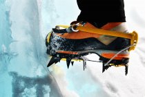 Cropped view of ice climbers feet wearing crampons — Stock Photo