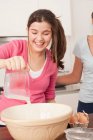 Teenage girls preparing food in kitchen — Stock Photo