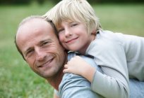 Vater und Sohn lächeln, konzentrieren sich auf den Vordergrund — Stockfoto