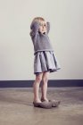 Girl standing in vintage wooden clogs with hands behind head — Stock Photo