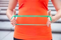 Cropped view of woman using resistance band — Stock Photo