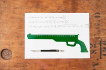 Gun shaped ruler and pen on paper, top view — Stock Photo