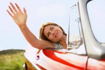 Hand einer Frau mittleren Alters aus dem Autofenster — Stockfoto