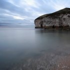 Довгий експозиційний знімок скель біля моря з хмарним небом — стокове фото