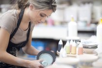 Potter starting design on plate at crockery factory — Stock Photo