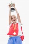 Smiling girl holding trophy, focus on foreground — Stock Photo